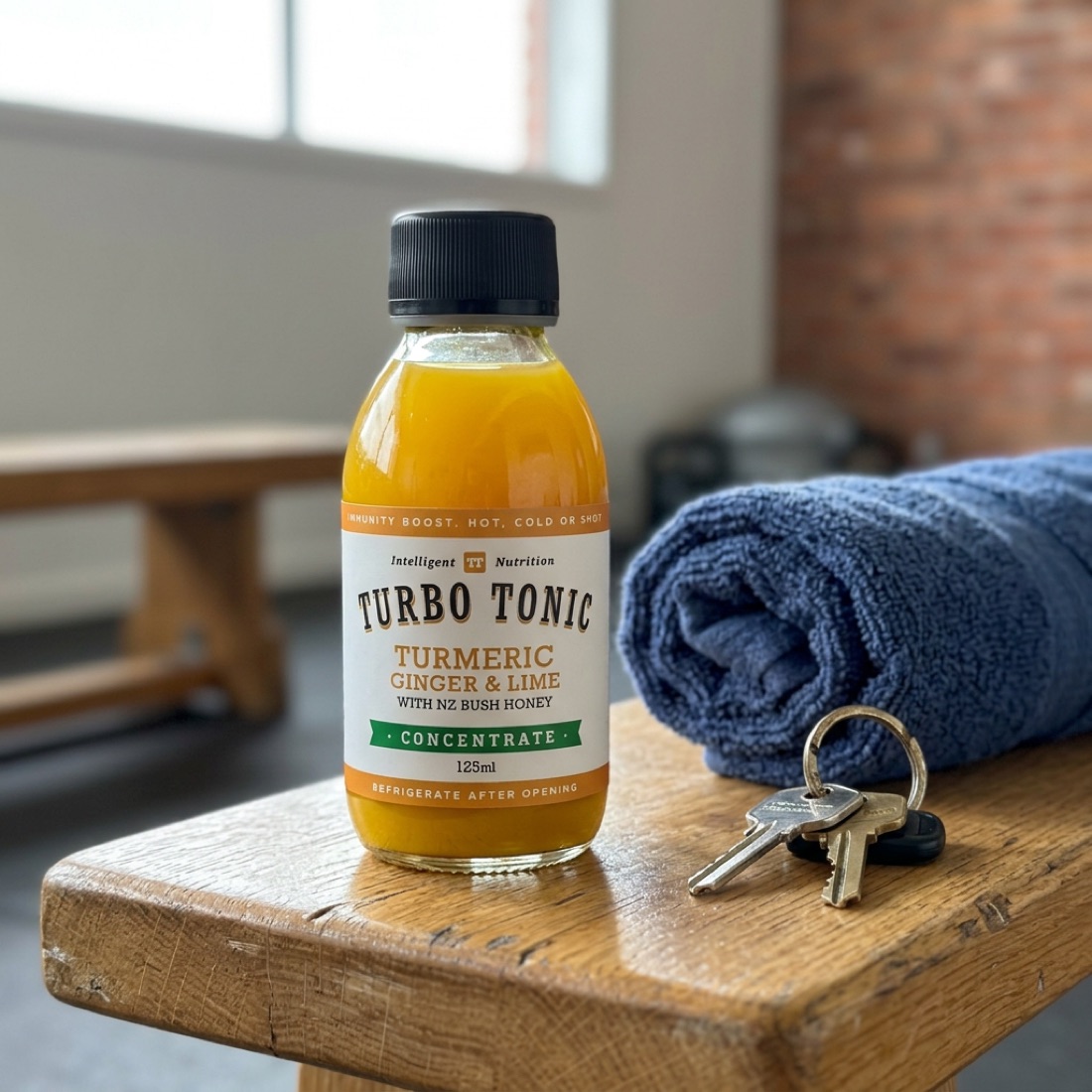 A 125 ml Turbo Tonic bottle on a gym bench beside a rolled towel